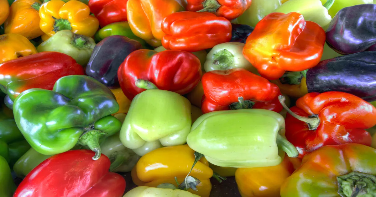 Many bell pepper varieites sitting on table