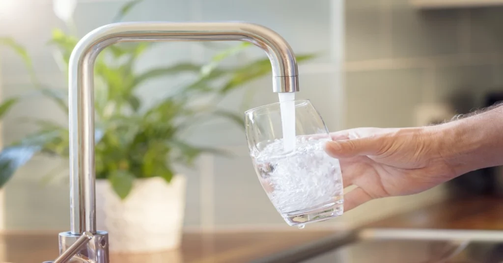 Filling a glass with water out of the kitchen sink faucet and dechlorinating it.