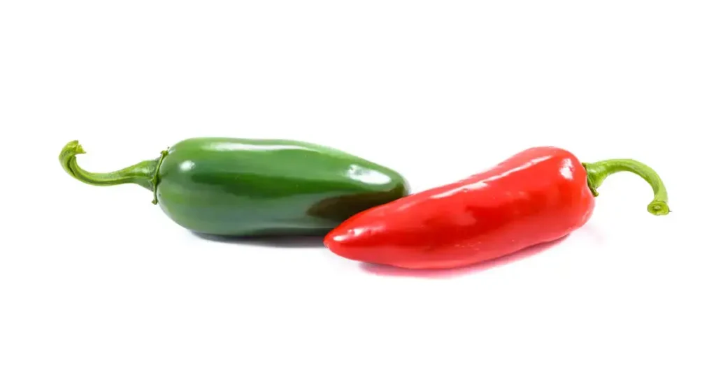 A green a red pepper with white background. Jalapeno vs. Serrano Peppers