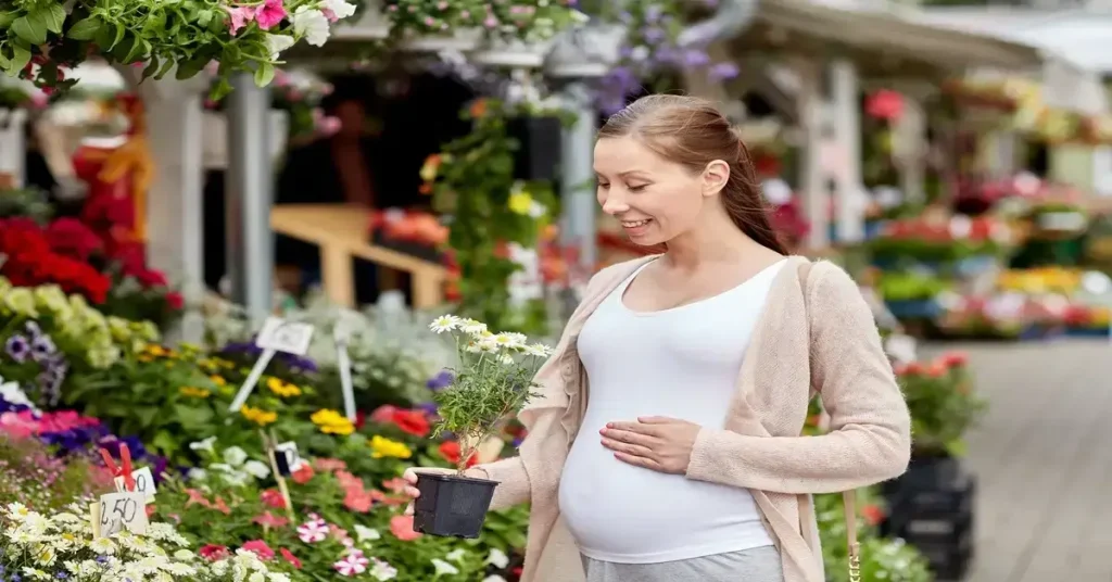 Pregnant woman shopping for plants for her garden.